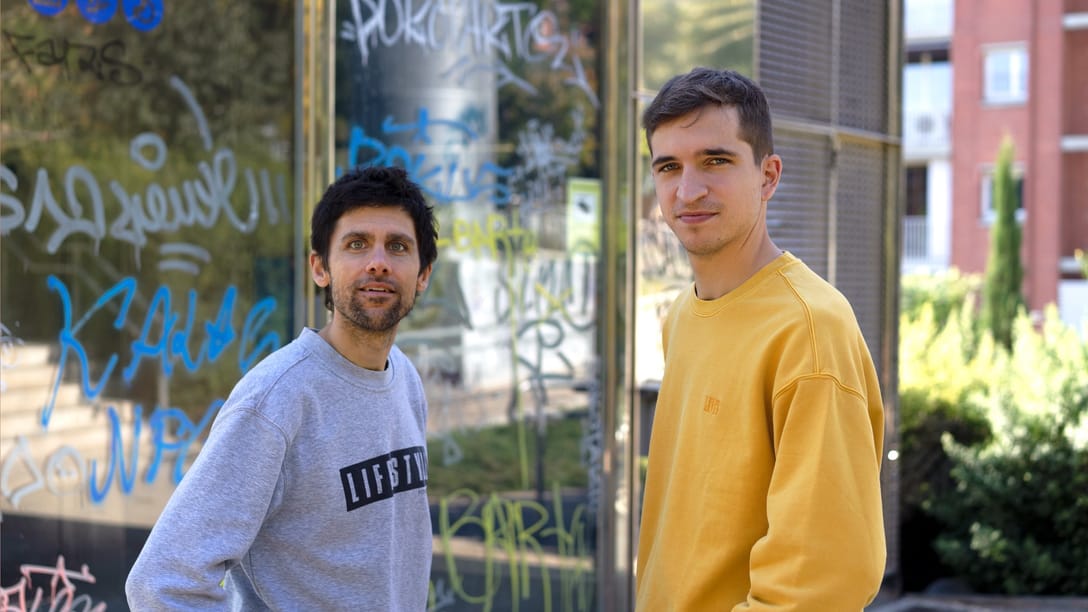 Marc and Ramon, the hosts of Safareig, in front of a graffiti-covered wall